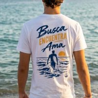 Parte trasera de una camiseta blanca surfera unisex con la frase: busca, encuentra y ama.
