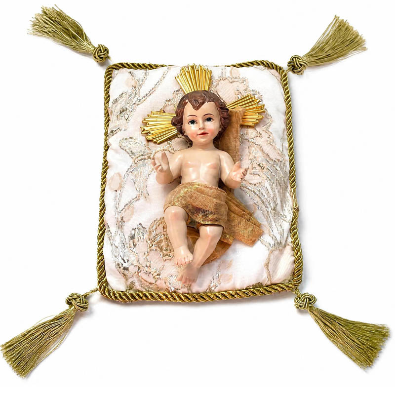 Niño Jesús de resina sobre cojín dorado