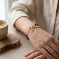 Pulsera decenario de plata de Ley 925 con baño en rodio dorado, con cuentas de onix y medalla de la Virgen con una pequeña cruz
